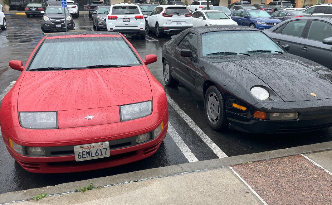 Nissan and Porsche parked in the rain